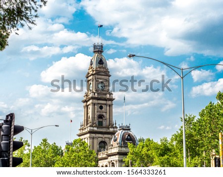 Town hall located in the suburb of Collingwood from Hoddle street public building. Blue sky, green trees. Royalty-Free Stock Photo #1564333261