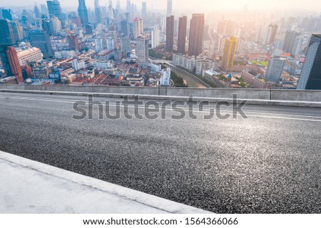 Empty asphalt highway and modern cityscape in Shanghai at sunset.