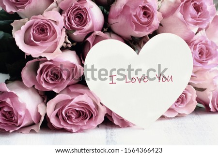 Beautiful retro soft pink rose flower background with wooden heart and text I Love You.