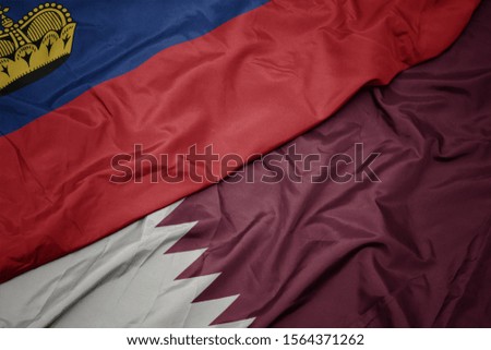 waving colorful flag of qatar and national flag of liechtenstein. macro