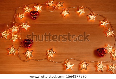 A garland of stars and three hearts on a wooden surface. the photo has space for text.