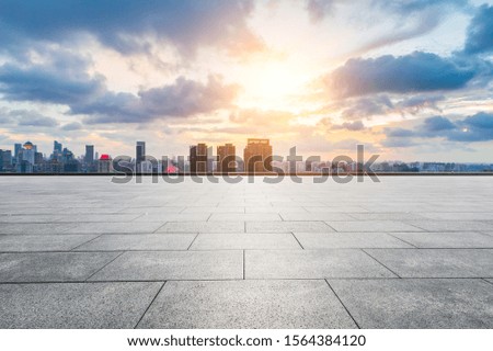 Empty square floor and modern cityscape in Shanghai at sunset.