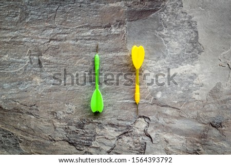 Plastic dart or arrows for darts game on grey background top view copy space