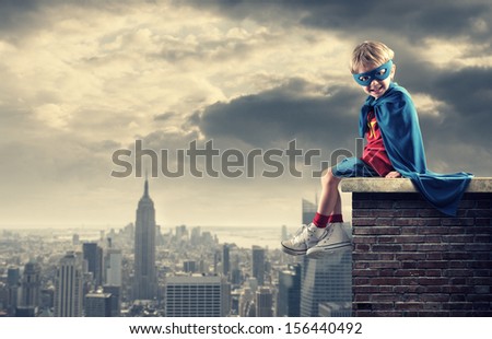 A young boy dreams of becoming a superhero. Royalty-Free Stock Photo #156440492