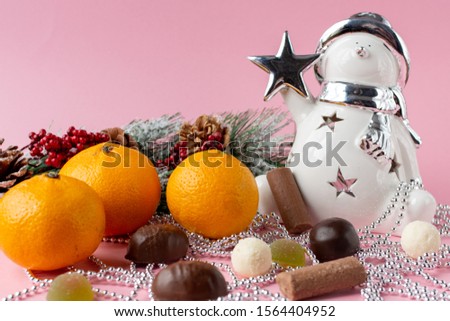 Christmas still life of candy lights, beads, snowman and Mandarin. New year mood. Happy new year.