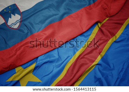 waving colorful flag of democratic republic of the congo and national flag of slovenia. macro