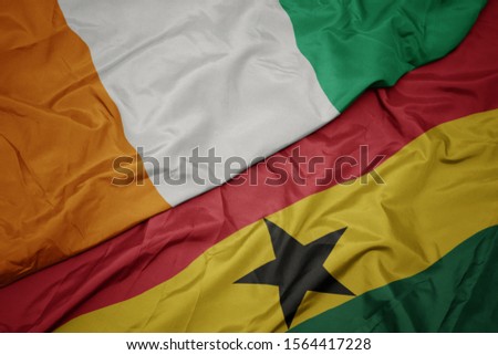 waving colorful flag of ghana and national flag of cote divoire. macro