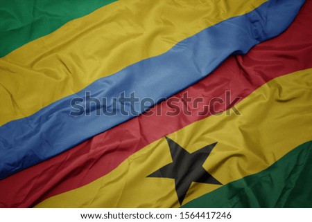 waving colorful flag of ghana and national flag of gabon. macro
