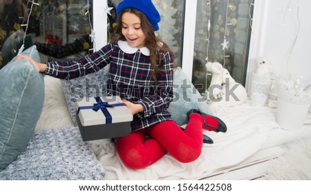 Dreams come true. Kid at home relaxing on cozy window sill. Magic moment. Happy winter holidays. Small girl opening gift. New year. Santa claus gift. Little girl child received gift. Present xmas.