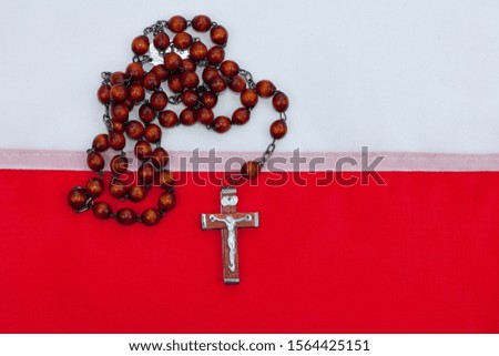 Rosary and polish flag in the  background. 