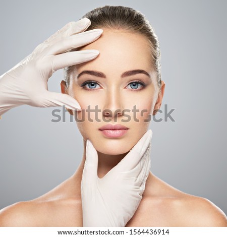 Face skin check before plastic surgery. Beautician touching woman face. Royalty-Free Stock Photo #1564436914