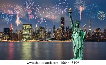 Statue of liberty in front of Manhattan skyline, in Dumbo at night, and fireworks