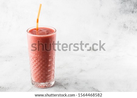Berries smoothie or raspberry pink, red milkshake in glass on bright marble background. Overhead view, copy space. Advertising for milkshake cafe menu. Coffee shop menu. Horizontal photo.