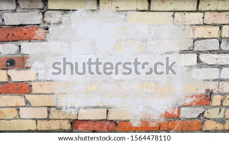 Background of texture of old colored brick. Photo walls of red, white, blue and green clinker brick. Ancient brick wall background for graffiti. Old plastered wall with cracks.
