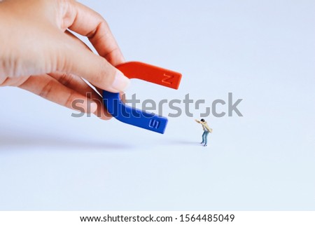 Miniature people man with magnet over white background,copy space.