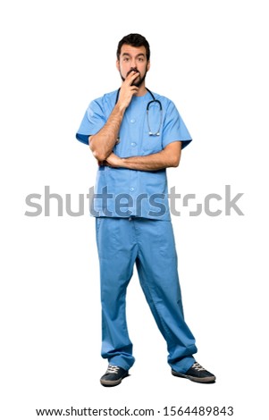 Full-length shot of Surgeon doctor man surprised and shocked while looking right over isolated white background