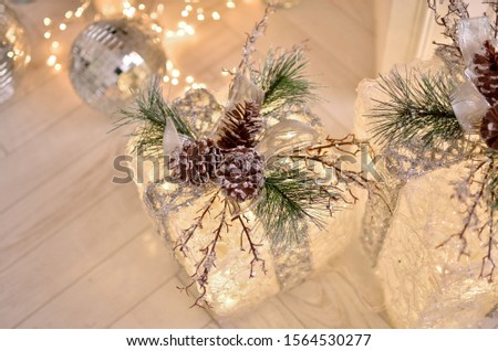 
A gift in transparent packaging, Christmas decor made of fir cones. Photo in bright colors