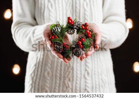 
Family Christmas traditions. Woman's hands have a beautiful handmade Christmas wreath. Close-up.