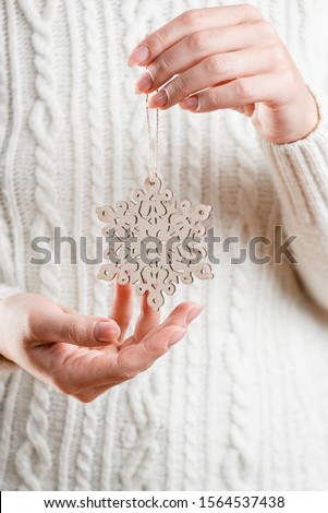 Traditions of Christmas celebration. Handmade christmas decoration in woman's hands. Close-up.