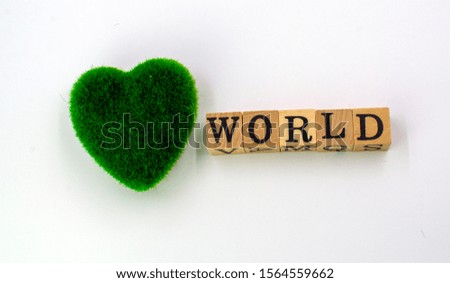 Green heart, word "WORLD" on a wooden cube.