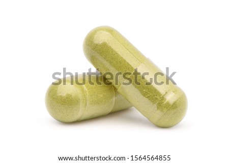 Close-up Two Herb powder capsules isolated on white background. Clipping path. Royalty-Free Stock Photo #1564564855