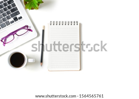 White office desk table with blank notebook, laptop computer and cup of coffee isolated on white background. Top view with copy space, flat lay.