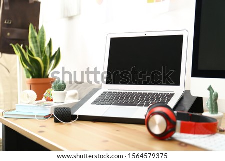 Modern laptop, computer and office supplies on wooden table, space for text. Designer's workplace