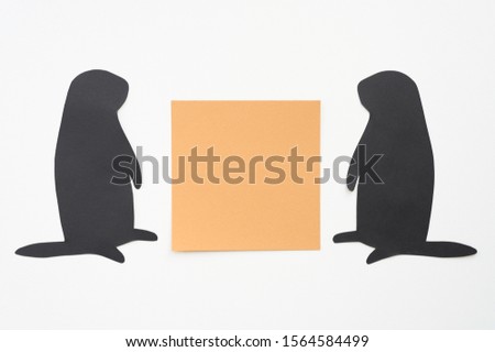 Groundhog day. Two groundhog silhouette cut from black paper and brown blank sticker writing paper on white background. Space for text