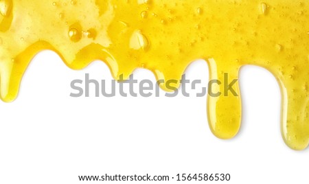Flowing yellow slime on white background. Antistress toy Royalty-Free Stock Photo #1564586530