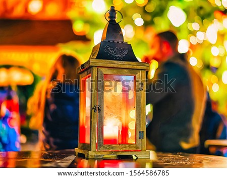 Bright candle lantern at the centre of the Christmas market in winter Riga of Latvia. Europe in winter. German street Xmas and holiday fair. Advent Decoration and Stalls with Crafts Items on Bazaar