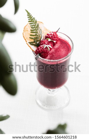 Fresh purple smoothie from fruit and vegetables for a healthy lifestyle isolated on bright marble background. Overhead view, copy space. Advertising for cafe menu. Vertical photo.