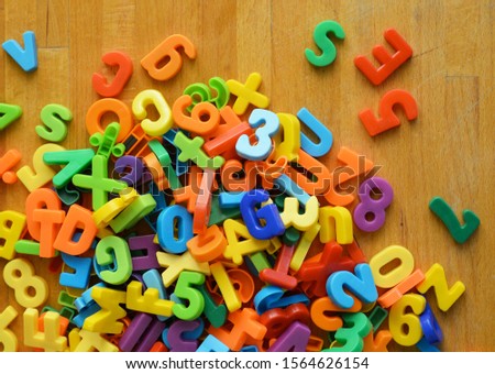 A group of colorful letters and numbers on a wooden ground