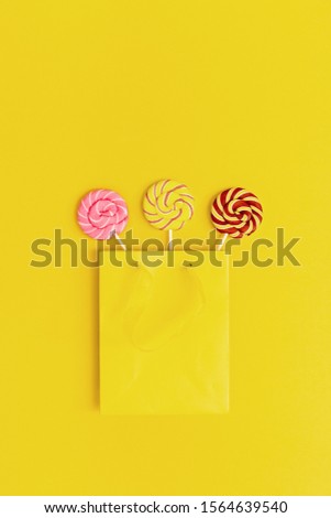 Colorful Lollypop sweets caramel candy on stick in yellow paper package. Bright background for postcard, or invitation for Birthday, party, Hen-party. 