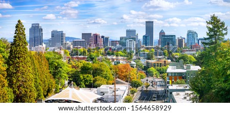 Classic panoramic view of famous Portland skyline with busy downtown scenery, colorful leaves and iconic Mount Hood in the background on a beautiful sunny day in fall, American Northwest, Oregon, USA