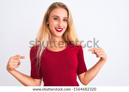Young beautiful woman wearing red t-shirt standing over isolated white background looking confident with smile on face, pointing oneself with fingers proud and happy.