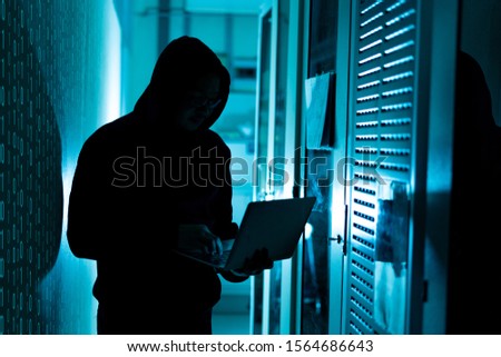 A computer programmer or hacker prints a code on a laptop keyboard to break into a secret organization system.