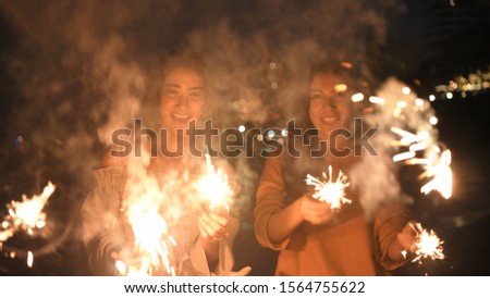 Holiday concept. Asian girls playing fun fireworks on the beach. 4k Resolution.