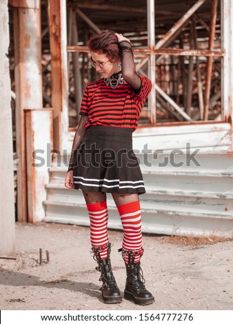 Vertical shot alternative gothic girl on an abandoned construction background. Emo teenager