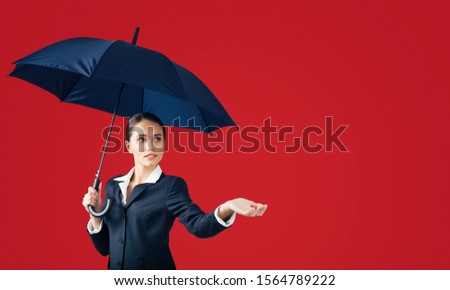 young happy emotional cheerful girl laughing and jumping with yellow umbrella   on colored red background