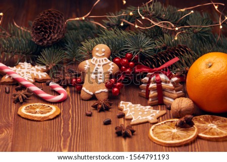 Christmas gingerbreads. Christmas decorations. Handmade cookies, fir branches with decorations on the wooden table.  Christmas and New Year treats.