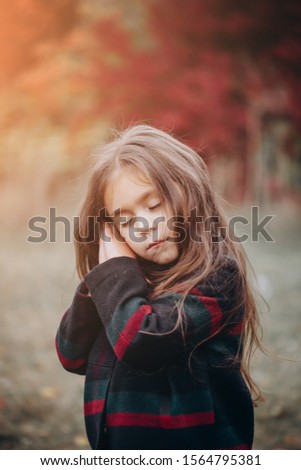 Close up Portrait of cute little girl in autumn forest.
