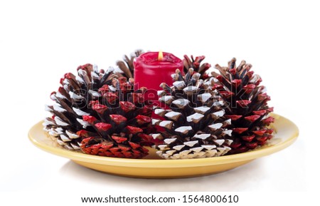 Multicolored cones and a burning candle. Christmas and New Year greeting card. isolated on a white background.