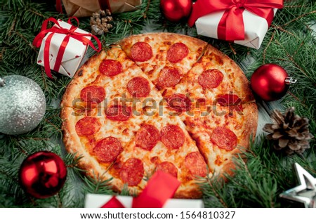 Christmas pepperoni pizza with Christmas decorations, gift, spruce, toys