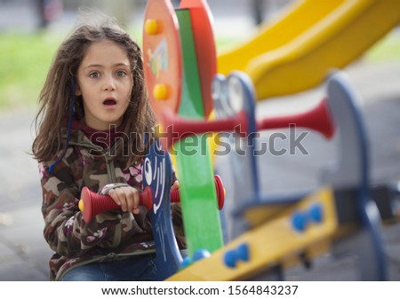 Portrait of a little girl 7 years old with long hair on the playground