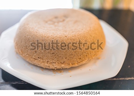 Small plain yellow vanilla homemade sponge birthday cake on white plate cooking preparation made with gluten free flour