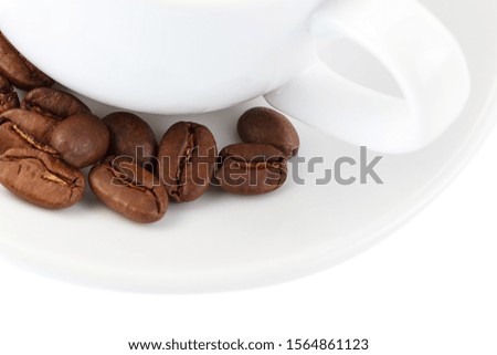 White coffee cup on saucer and roasted beans isolated on white background. Close-up.