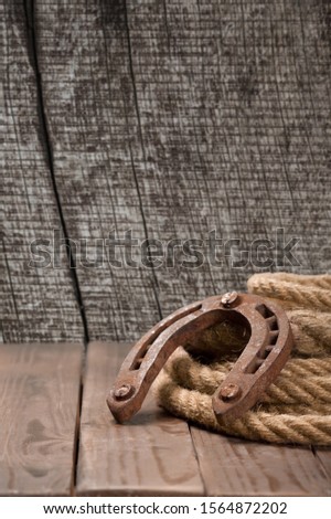 Old horseshoe, lariat lasso and cowboy hat on wooden desk