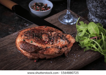 Roasted piece of meat on wooden board. Roasted Dinner served with salad and wine. Roast Pork. 