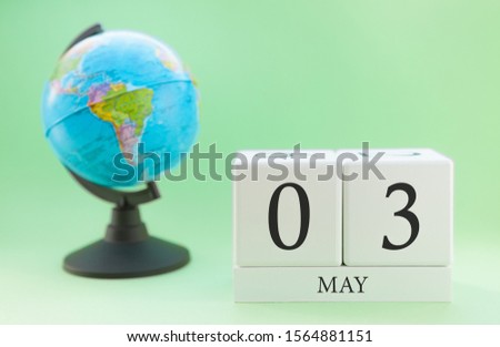 Spring calendar for May 3 on a green background, the concept of heat and holidays