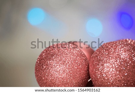Christmas background with shiny colored toys.  Background with blurred lights garlands, pink toys on one side of the picture. Copy space